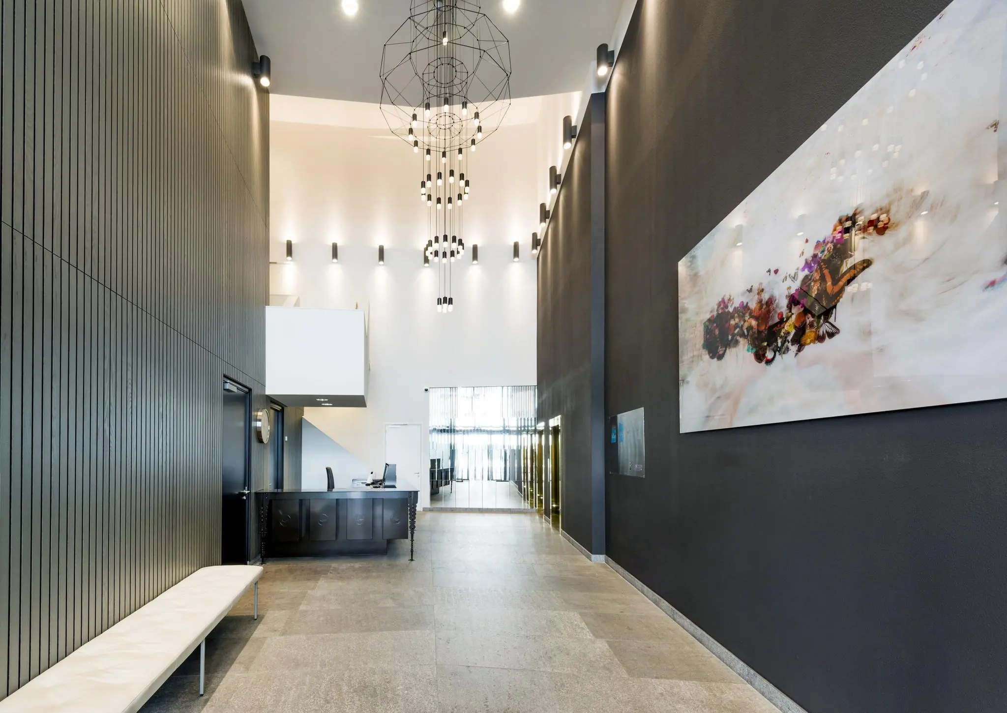 Moderne ontvangsthal aan de Grote Marktstraat met hoge plafonds, strakke inrichting en kunst aan de muur.